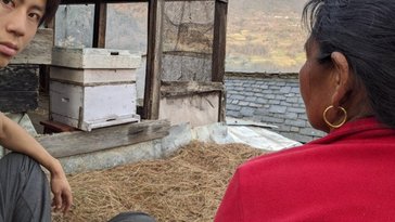 Jeff and a local farmer inspecting beehive