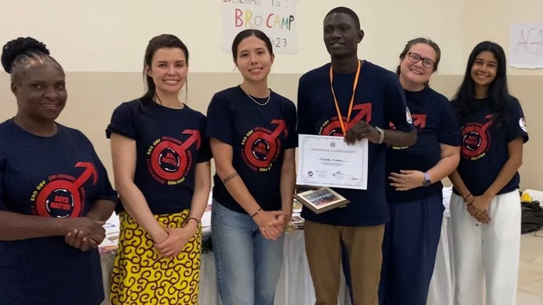 The Volunteer with a group of community members and other Volunteers posing with a certificate.
