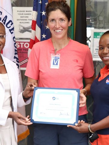 A woman receives a certificate from two other women