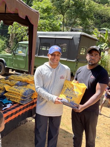 Two men hold a sack of rice
