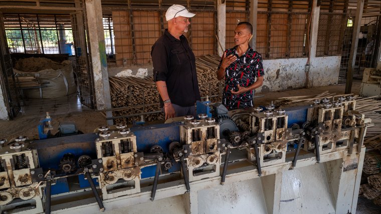 Volunteer and counterpart talking at a factory.