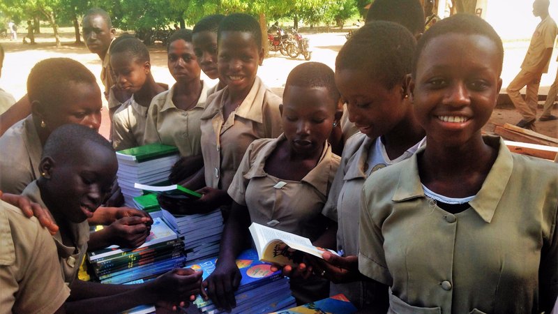 Girls receiving books from the "Books for Benin" project.