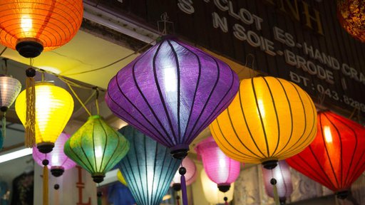 Hanging lanterns of different colors and shapes light up the entrance of shop.