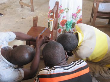 Three students looking at experiment being conducted on a chair