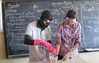 Two people in front of board with googles conducting science experiment