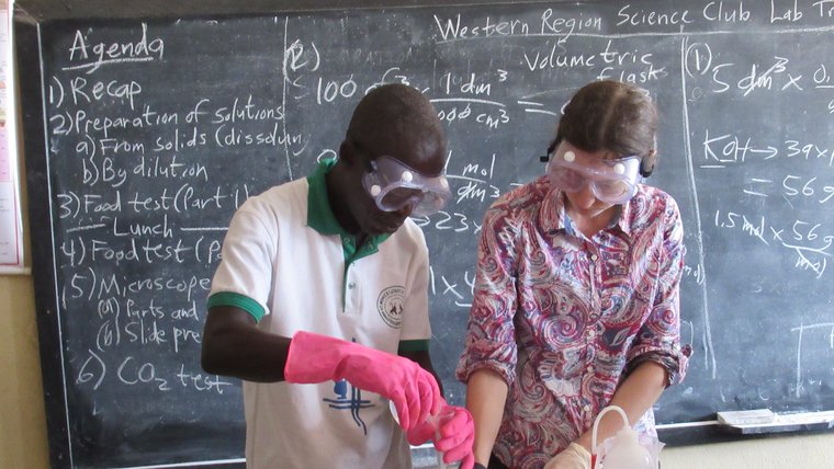 Two people in front of board with googles conducting science experiment