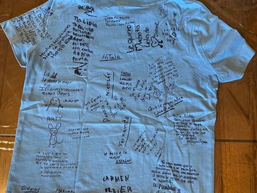 A white cotton tee covered in black marker signatures