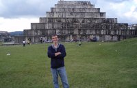 A man stands in front of an ancient tomb