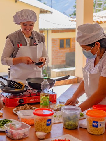 Lucy and community health workers give a nutrition training about iron rich foods.