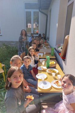 13 elementary students enjoy lunch outside