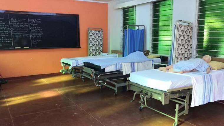 Three hospital beds lined up next to each other with mannequins on each bed