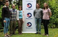 five volunteers next to a peace corps sign