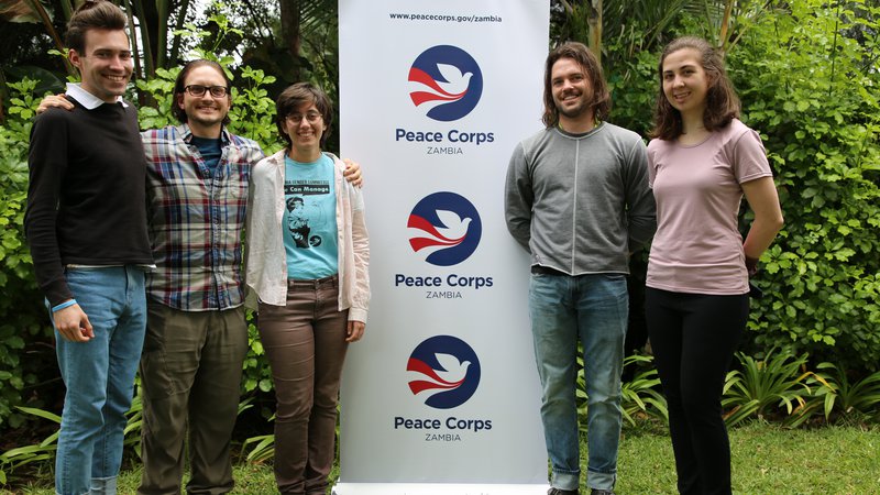 five volunteers next to a peace corps sign