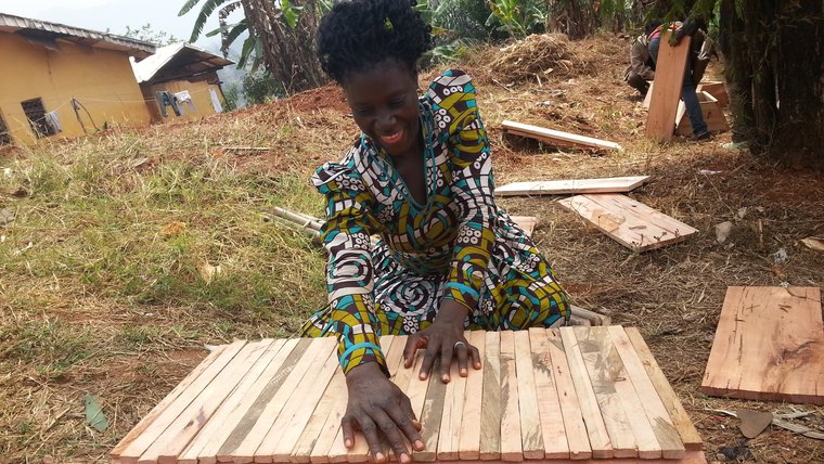 Madame Victorine Chia displays the beehive that she built after a technical session on hive construction