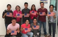 8 people holding up American flag