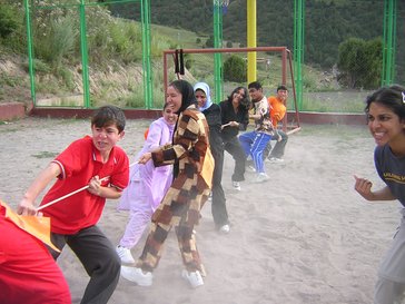 Several kids playing pulling a rope