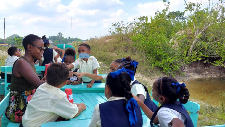 Mary with her students in an outdoor classroom in Guyana.