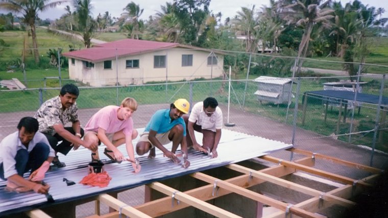 A Peace Corps Volunteer on a roof with Fijian men.