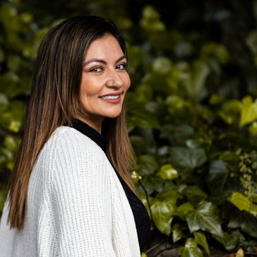 A Colombia woman stands in front of ivy plants