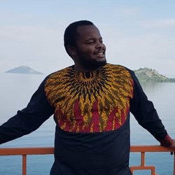 Moses Wamalwa portrait standing in front of a lake.