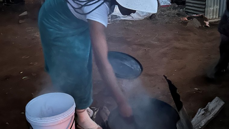 Nadirah cooks over a fire