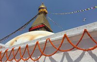 A close up shot of a Nepal temple tower with prayer flags