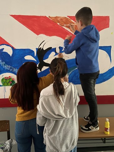 our cohort created a recycling competition. Four dedicated students painted a mural with decorations made from plastic bags and bottle caps