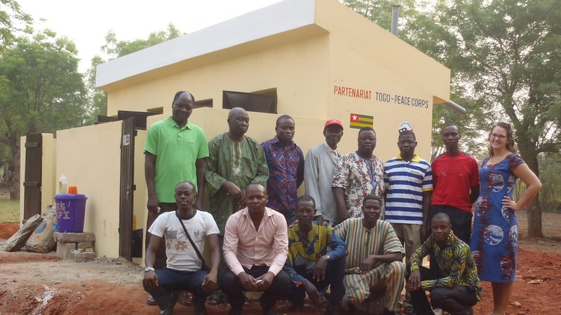 Togo: Community members pose with a Volunteer in front of the new latrines.