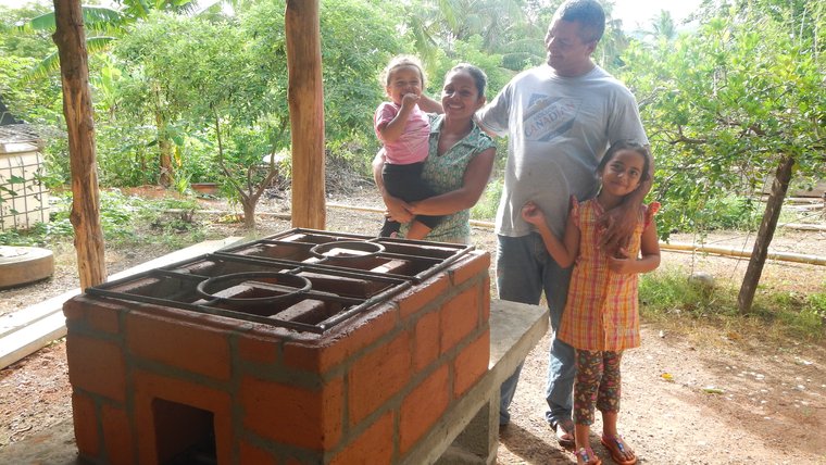 a Panamanian family smiles in front of an eco-stove