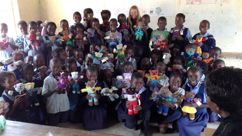 A Peace Corps Zambia Volunteer and her second grade class pose for a photo.