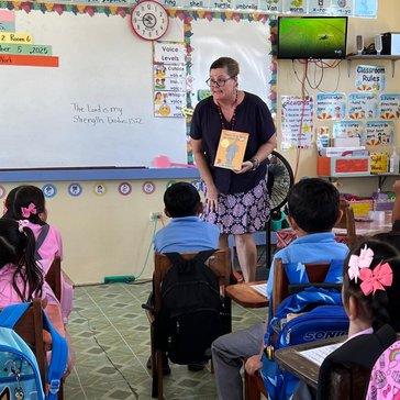female teacher in the front of the classroom teaching literacy to children