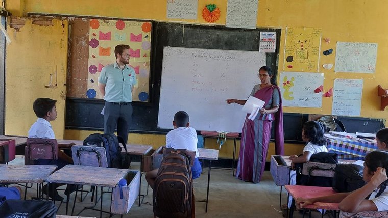 Male PCV and female teacher clad in saree teaching students in the classroom