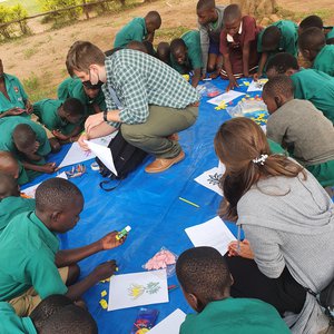 Peace Corps Volunteer reading with Ugandan children