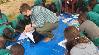 Peace Corps Volunteer reading with Ugandan children