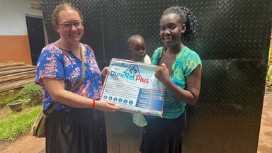 PCV distributes mosquito net to mother and child