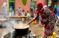 woman cooking over fire
