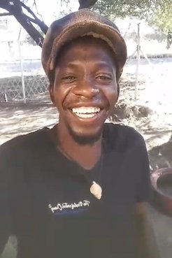 One Namibian man in a hat smiles for a selfie