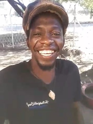 One Namibian man in a hat smiles for a selfie