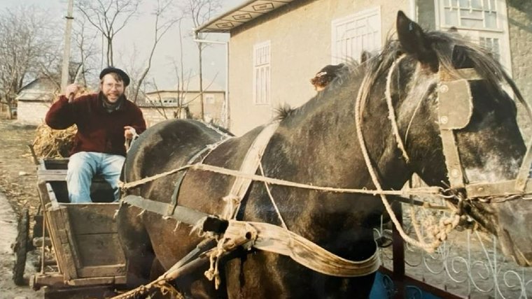 A man drives a horse-drawn carriage.