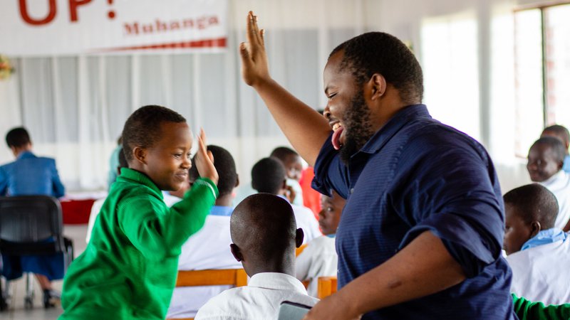 PCV Moses gives a high-five to a student