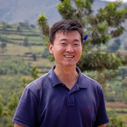 Portrait of PCV Alex with Rwandan hills in the background