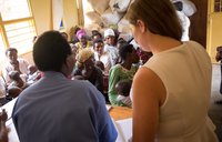 PCV Caroline and her counterpart stand facing the women's group during their presentation.
