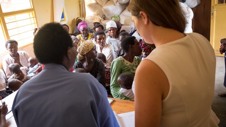 PCV Caroline and her counterpart stand facing the women's group during their presentation.