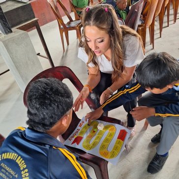 Volunteer Kennedy T. plays English learning games with students in Nepal.