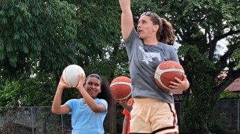 Peace Corps Volunteer Teaches Young Girl to Shoot a Basketball