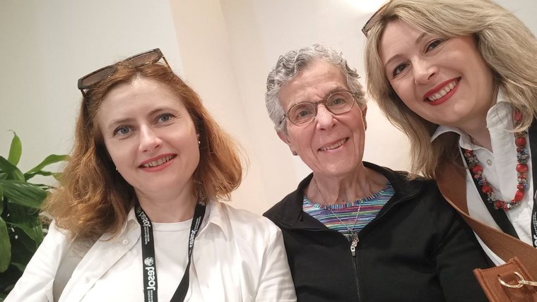 Three women smile for a selfie