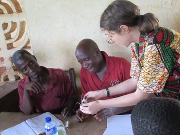 Two people sitting down and one person teaching them