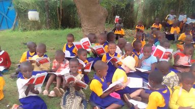 Ugandan children readong on DEAR Day