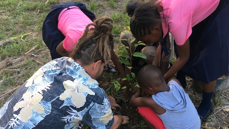 Planting a tree in Jamaica during Andrew's in-person service in Jamaica.