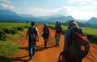 Four Volunteers walk together towards a mountain on their vacation in Malawi